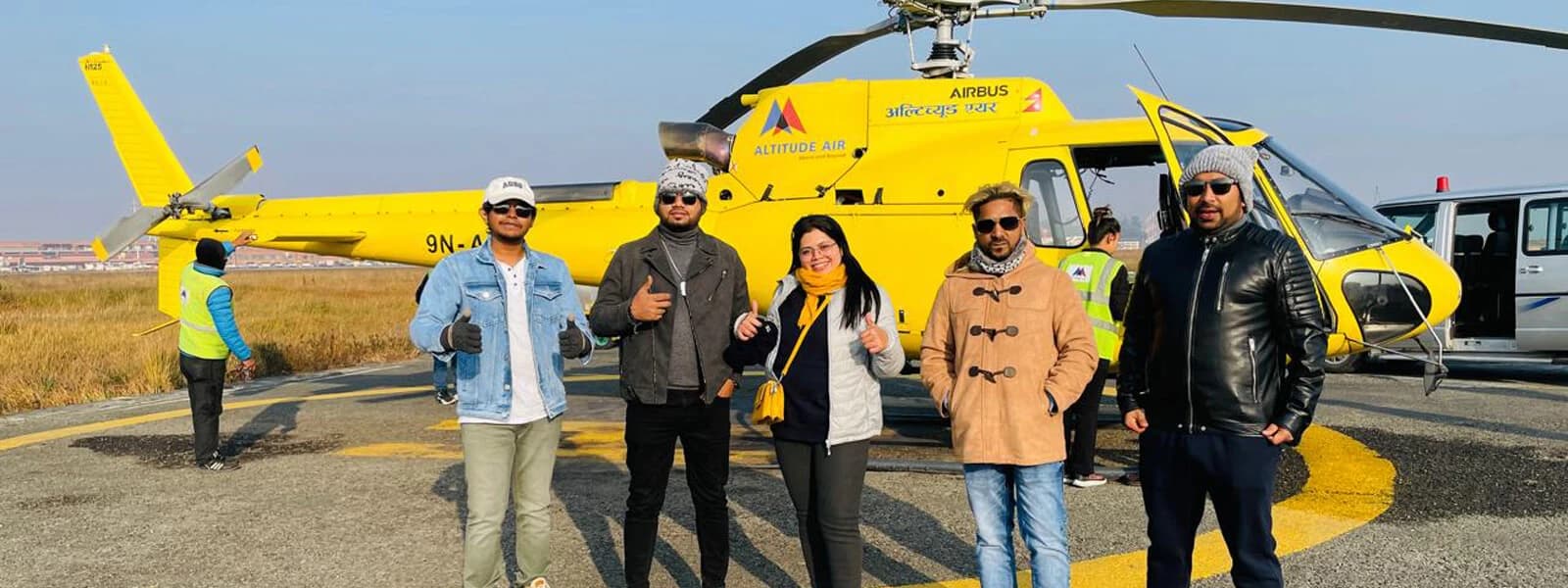 Guests ready to board a helicopter on a helipad for a visit to Gosainkunda Lake, with mountains in the background.