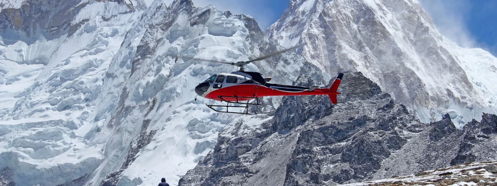 Helicopter flying over the sacred Muktinath temple surrounded by mountains.
