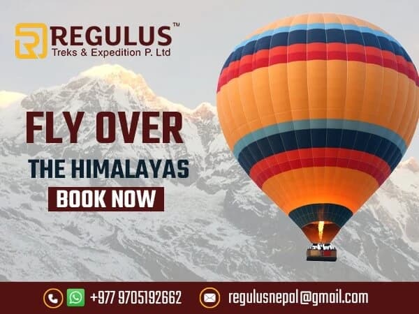 Hot air balloon flying over the mountains in Nepal at sunrise.